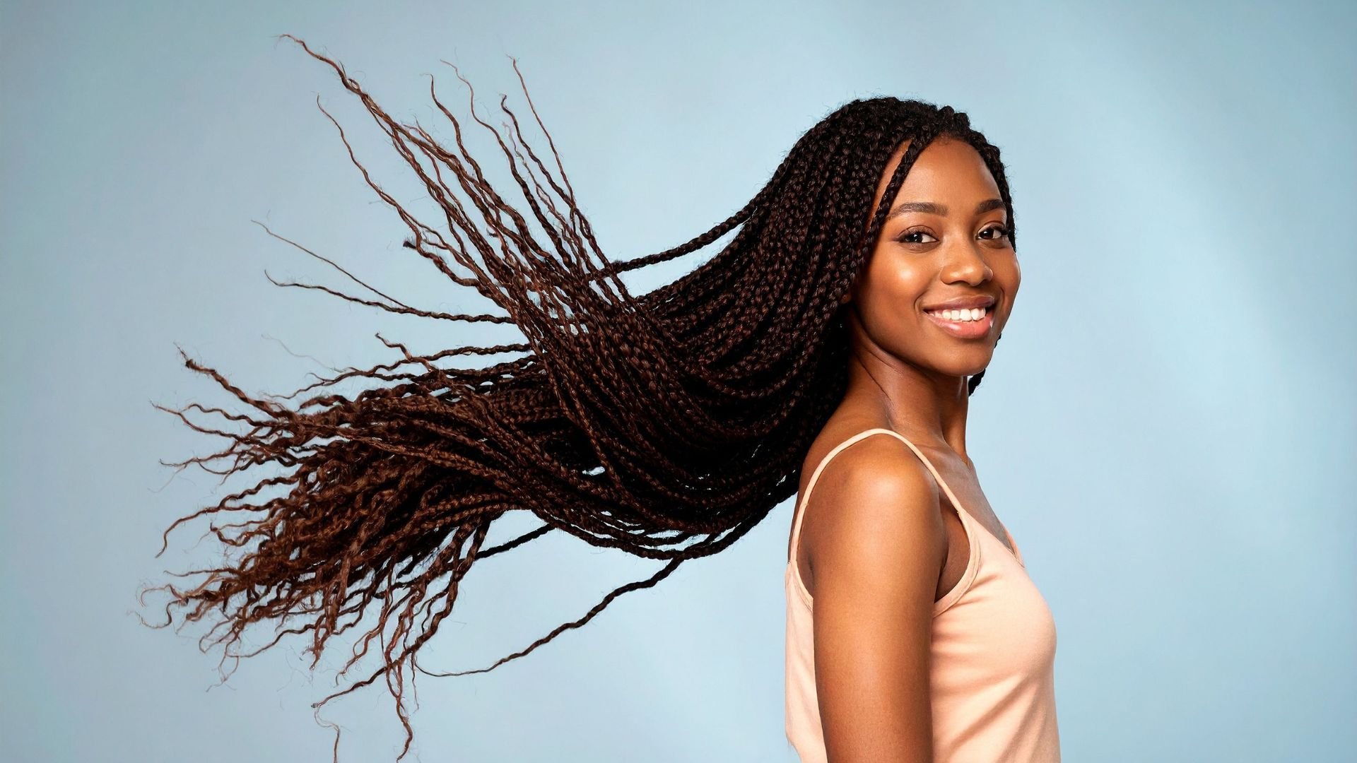 Smiling woman with flowing braids swinging in dynamic motion