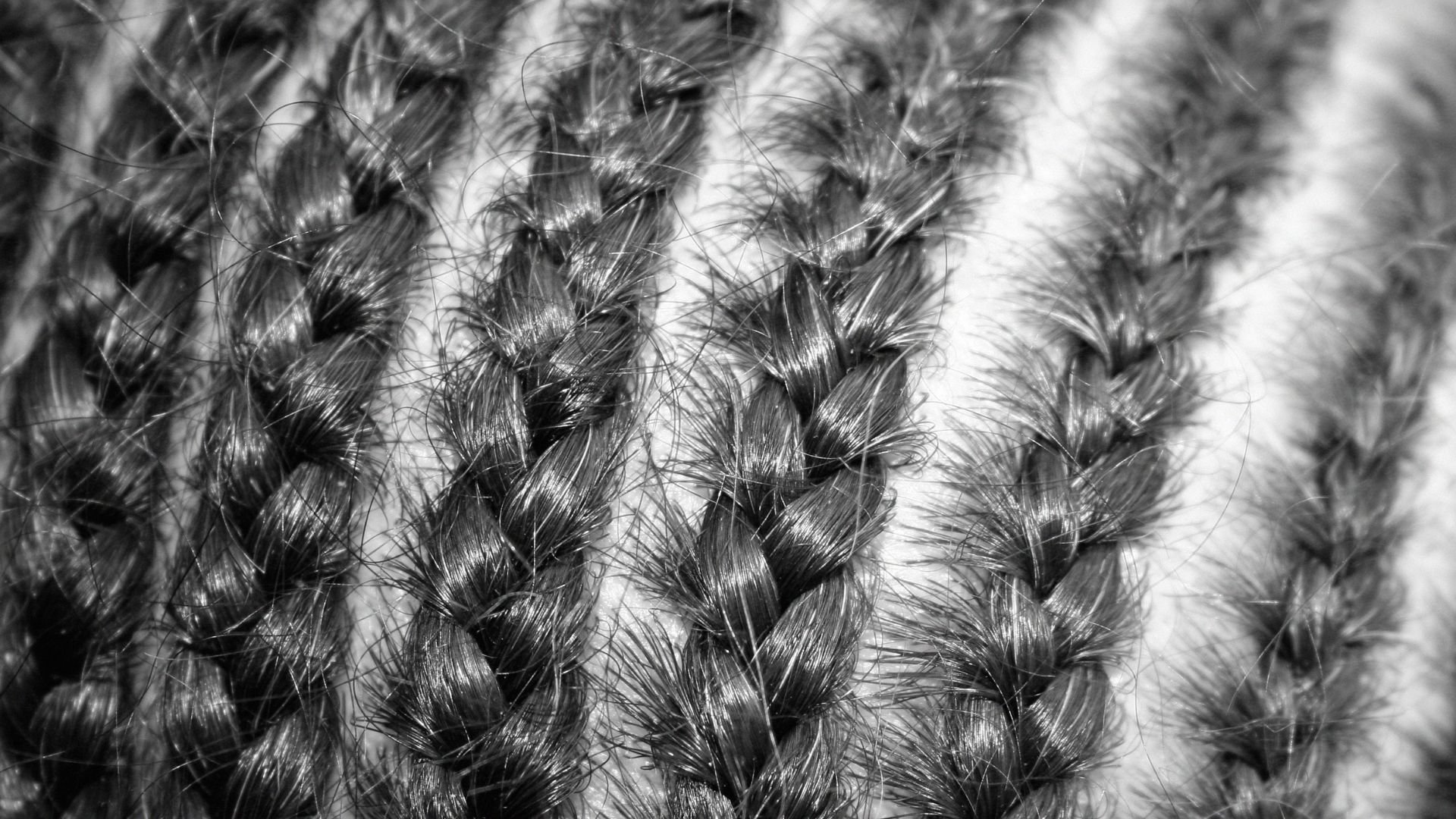 Black and white close-up of braided hair with intricate texture
