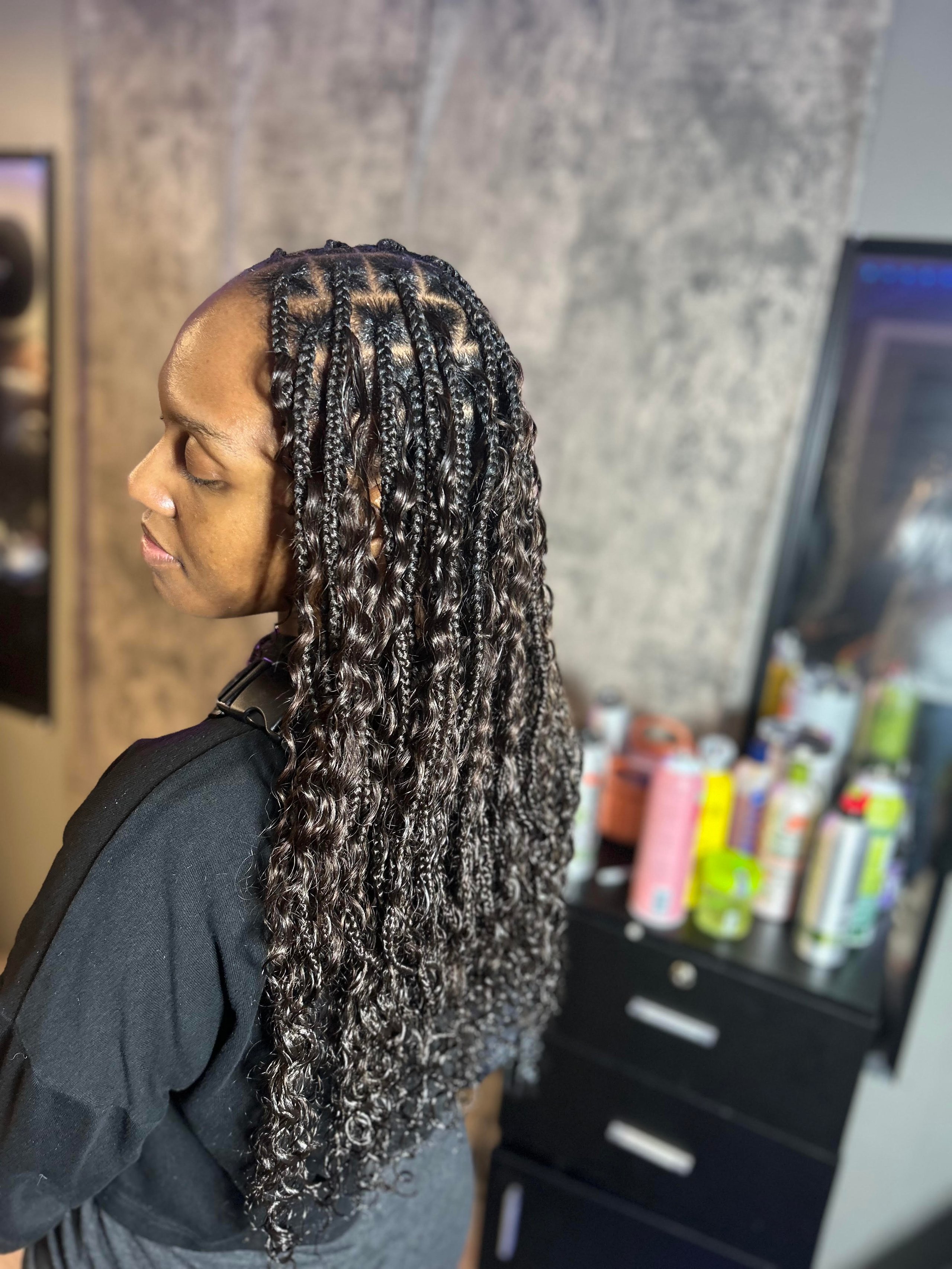 Detailed braided hairstyle with curly ends in a hair salon